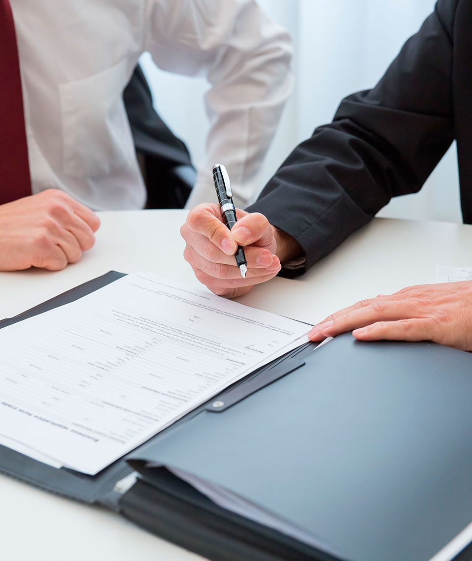 Cliente firmando un documento durante una consulta legal